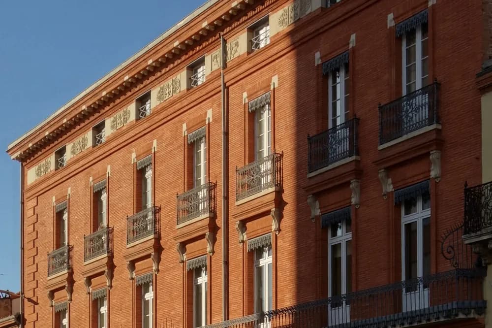 Façade de brique rose d'un immeuble de rapport du XIXe siècle, rue du Pont-Guilheméry à Toulouse