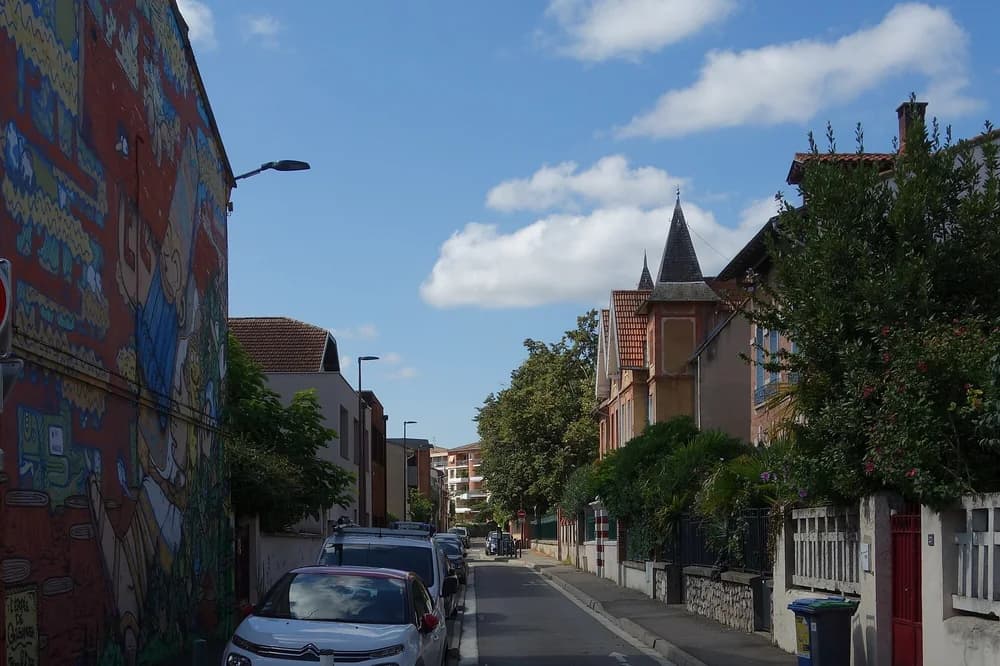 Rue résidentielle du Busca à Toulouse, maisons de brique et voitures garées